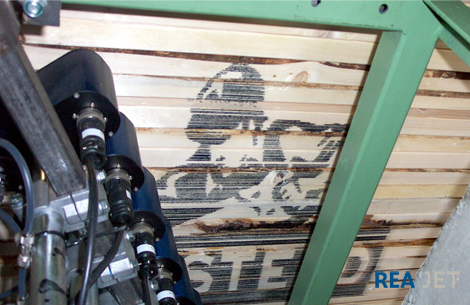 Foto: 32-nozzles Large Character printing system - The side of a wood stack marked with a 700x1200 mm high logo